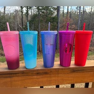A colorful collection of Starbucks studded cups including a LE Disney 50th